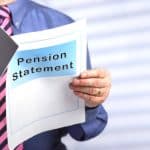 pension review statement being rad by man in a blue shirt and red tie